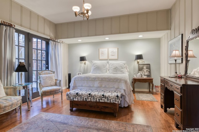 bedroom with hardwood / wood-style floors and a notable chandelier