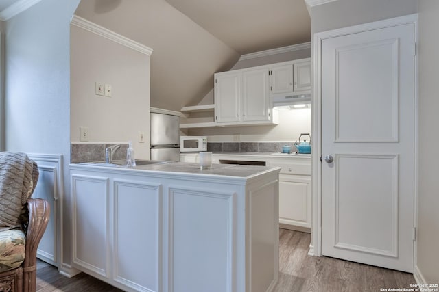 kitchen with white cabinetry, sink, stainless steel refrigerator, and light hardwood / wood-style floors