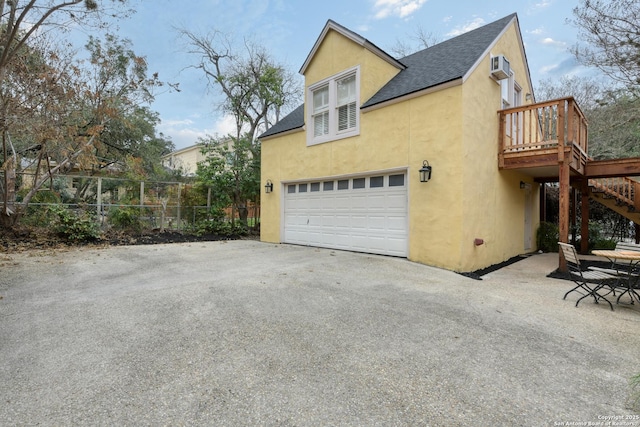 view of home's exterior featuring a garage and a wall unit AC