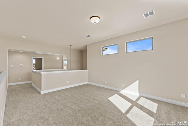 unfurnished room featuring light carpet, baseboards, and visible vents