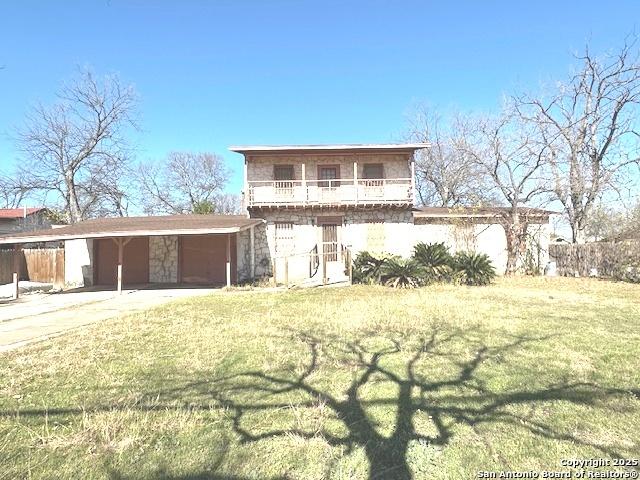 view of front property with a front lawn and a balcony