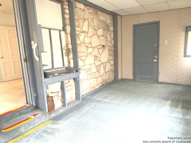 interior space featuring a paneled ceiling and carpet flooring