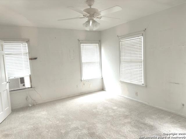 carpeted spare room featuring ceiling fan