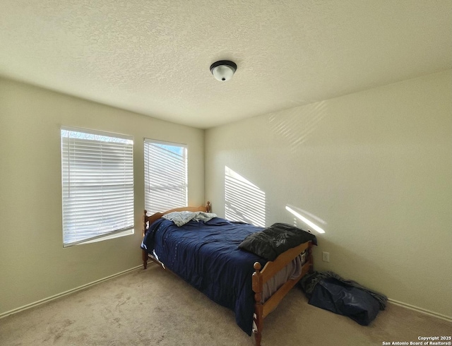 bedroom featuring a textured ceiling and light carpet