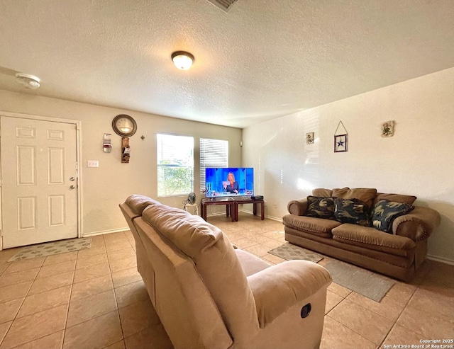 living room featuring light tile patterned floors and a textured ceiling