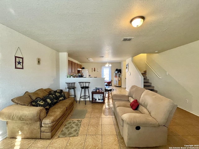 living room featuring a textured ceiling and light tile patterned flooring