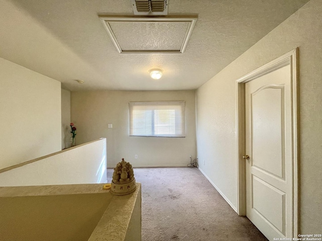 corridor with carpet floors and a textured ceiling