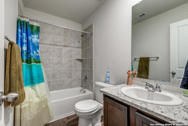 full bathroom featuring hardwood / wood-style floors, toilet, vanity, and shower / tub combo