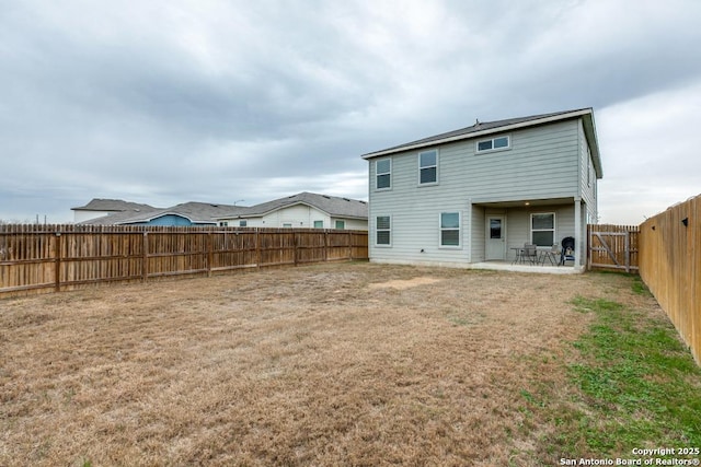 back of property with a patio area and a yard