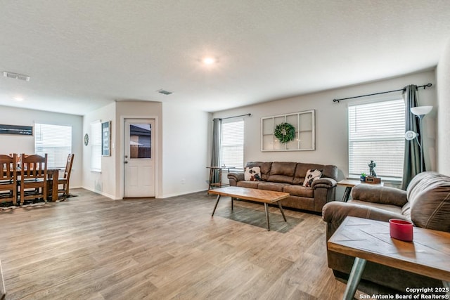 living room with light wood-type flooring and a textured ceiling