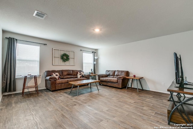 living room with hardwood / wood-style flooring and a textured ceiling