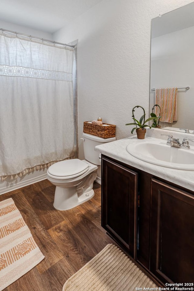 full bathroom with toilet, shower / bath combo, hardwood / wood-style flooring, and vanity