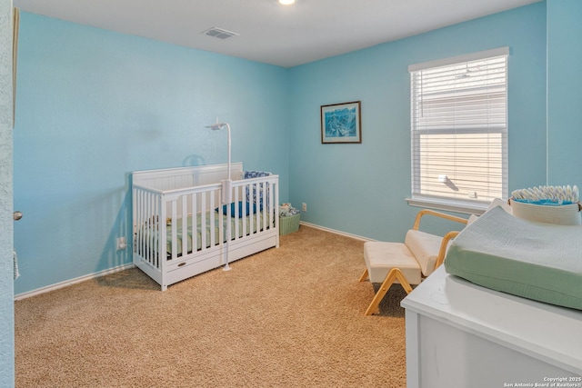 bedroom with carpet and a nursery area