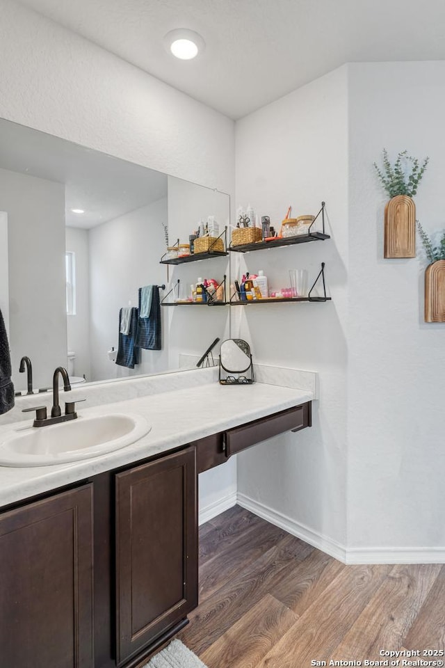 bathroom featuring wood-type flooring, toilet, and vanity