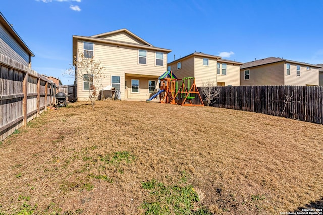 back of property featuring a yard and a playground