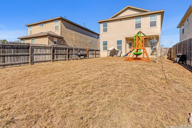 rear view of house featuring a playground