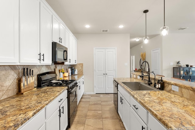 kitchen with tasteful backsplash, hanging light fixtures, black appliances, white cabinets, and sink