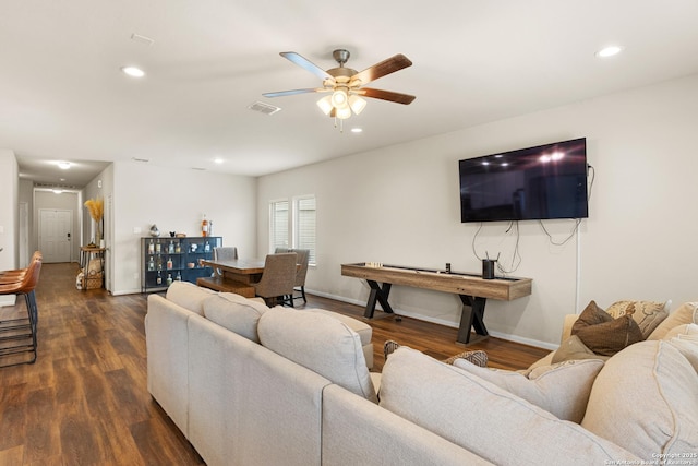living room featuring ceiling fan and dark hardwood / wood-style floors