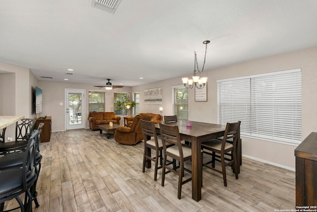 dining room featuring light hardwood / wood-style floors and ceiling fan with notable chandelier