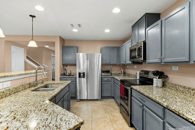 kitchen featuring hanging light fixtures, appliances with stainless steel finishes, sink, and gray cabinetry