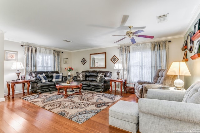 living room with ceiling fan, ornamental molding, and light wood-type flooring