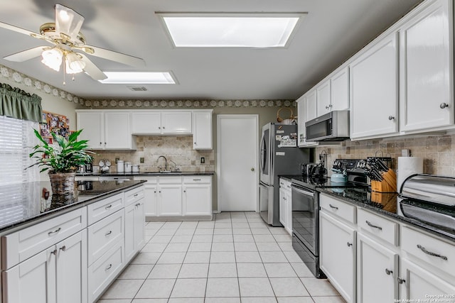 kitchen featuring backsplash, sink, white cabinets, and appliances with stainless steel finishes