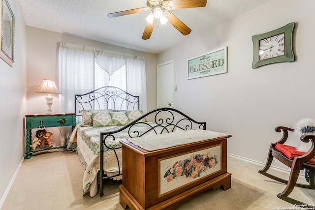 bedroom with a textured ceiling, ceiling fan, and light colored carpet