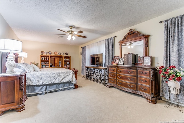 bedroom featuring ceiling fan, a textured ceiling, and light carpet