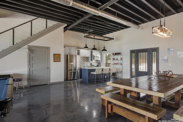 dining area featuring a towering ceiling