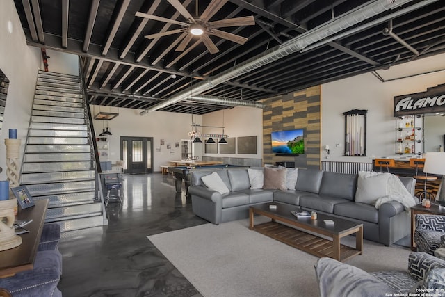 living room with a towering ceiling and concrete flooring