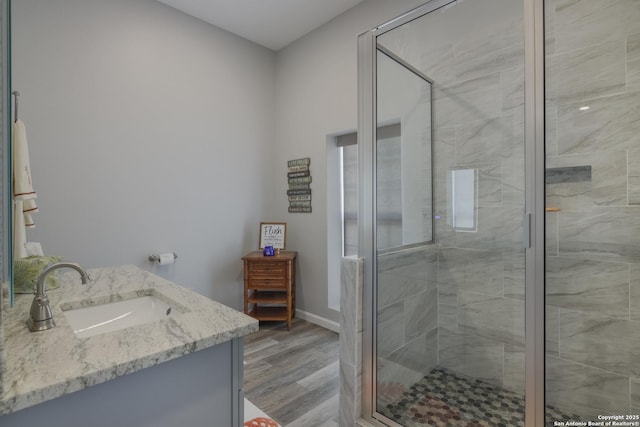 bathroom with vanity, a shower with shower door, and hardwood / wood-style flooring