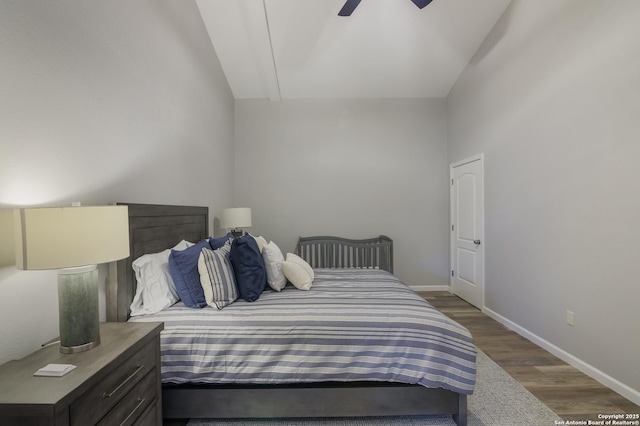 bedroom with dark wood-type flooring, vaulted ceiling, and ceiling fan