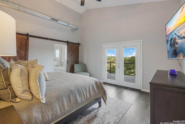 bedroom with ceiling fan, ensuite bathroom, dark wood-type flooring, a barn door, and access to exterior