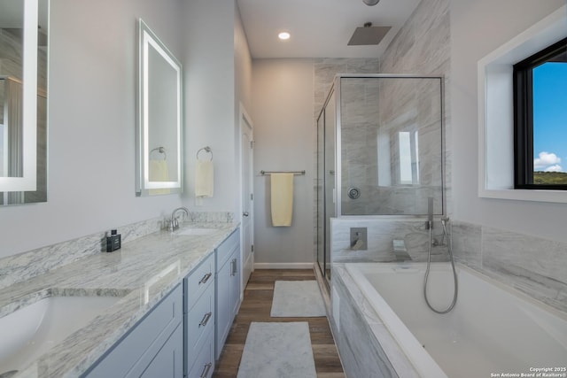 bathroom with vanity, shower with separate bathtub, and hardwood / wood-style floors