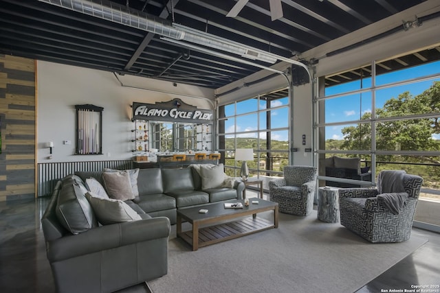 living room with a high ceiling, concrete flooring, and plenty of natural light