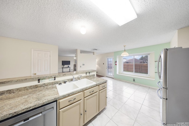 kitchen featuring pendant lighting, sink, a textured ceiling, stainless steel appliances, and cream cabinets