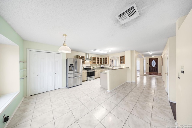 kitchen featuring kitchen peninsula, stainless steel appliances, decorative light fixtures, light tile patterned flooring, and wall chimney exhaust hood