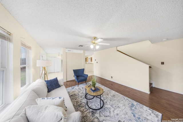 living room featuring a textured ceiling, ceiling fan, and hardwood / wood-style floors