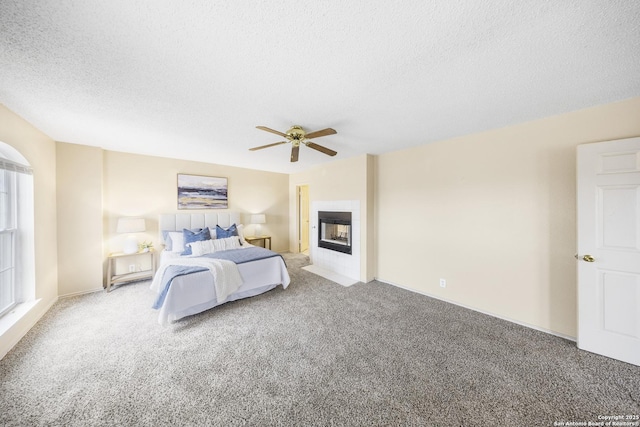 carpeted bedroom with ceiling fan and a textured ceiling