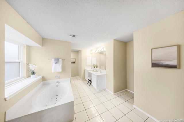 bathroom featuring a textured ceiling, a bathing tub, tile patterned flooring, and vanity