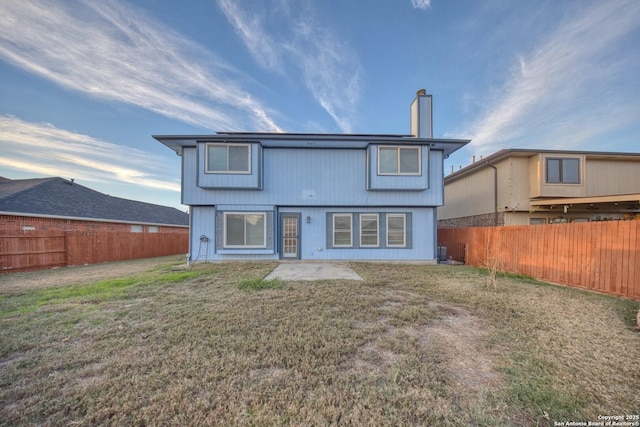 rear view of house featuring a patio area and a yard