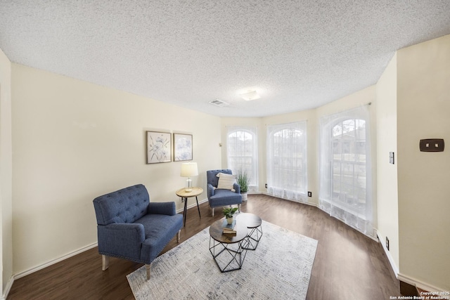 sitting room with a textured ceiling, dark hardwood / wood-style floors, and a healthy amount of sunlight