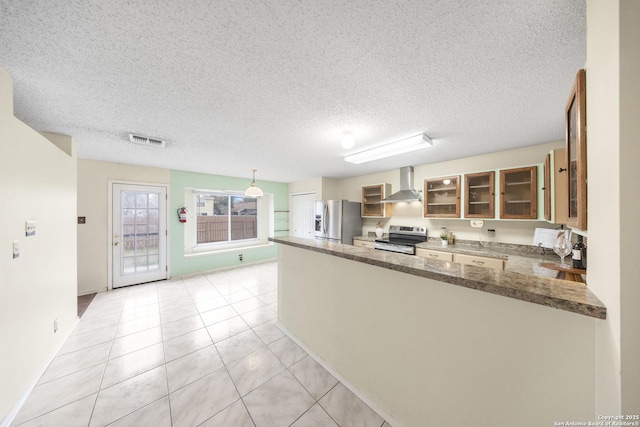 kitchen with kitchen peninsula, light tile patterned floors, stainless steel appliances, and wall chimney exhaust hood