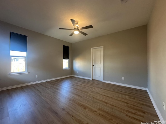 spare room featuring ceiling fan and dark wood-type flooring