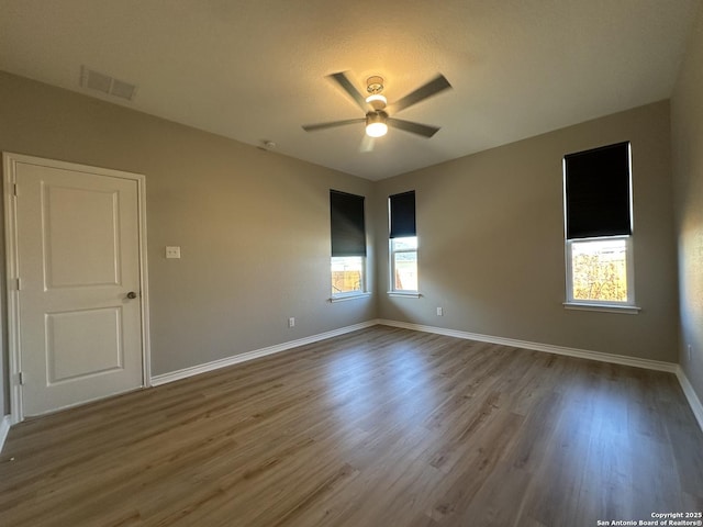 spare room featuring ceiling fan, plenty of natural light, and hardwood / wood-style floors