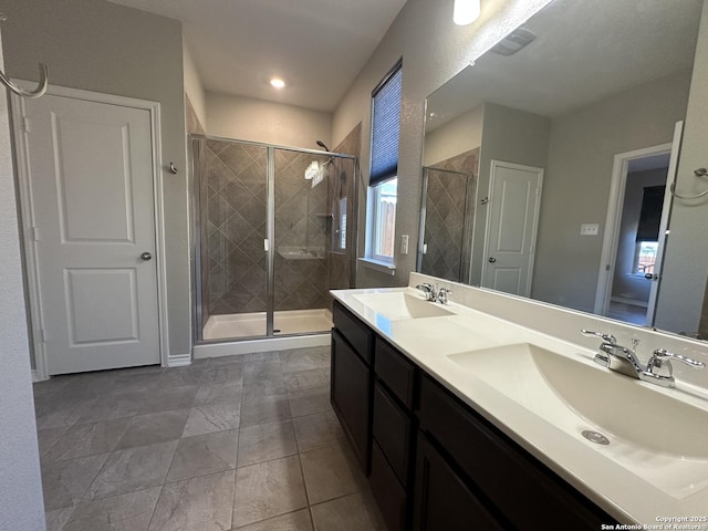 bathroom featuring a shower with shower door and vanity