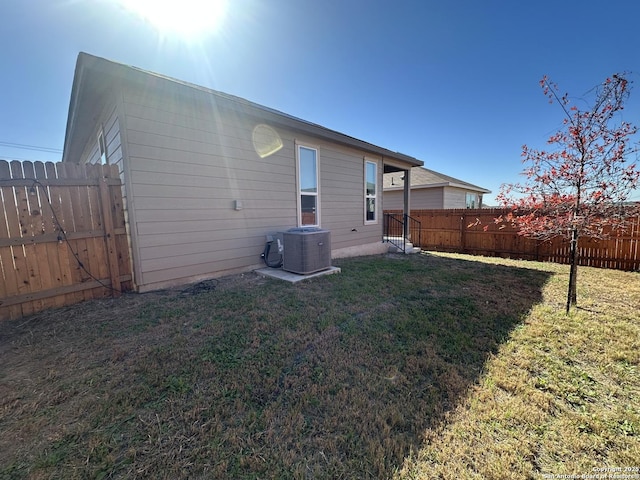 back of house with a yard and central AC unit