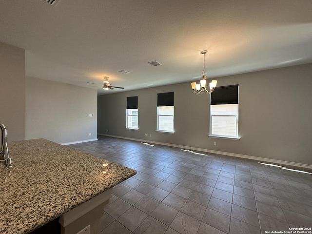 interior space with tile patterned floors and ceiling fan with notable chandelier