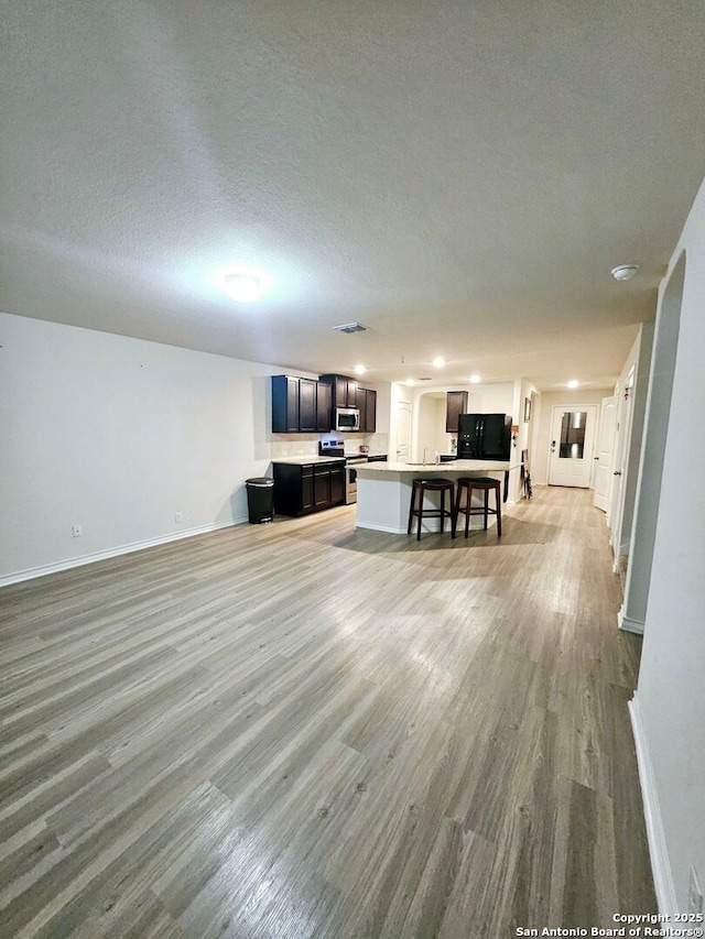 living room featuring a textured ceiling and light hardwood / wood-style flooring