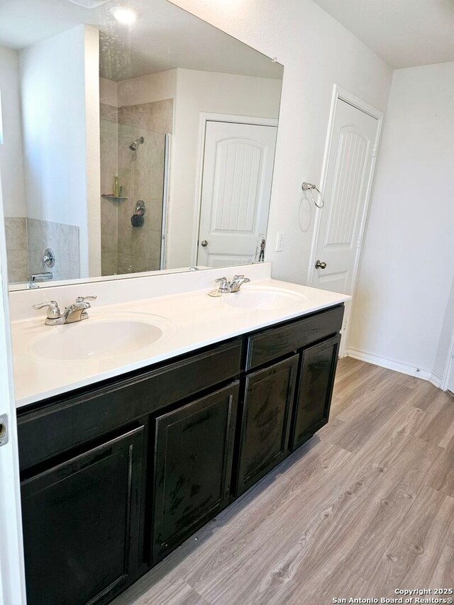 bathroom featuring wood-type flooring, an enclosed shower, and vanity